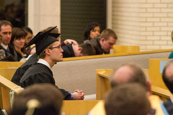 A student prepares for Convocation to begin in the Taylor Chapel.