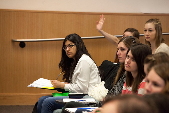 A student raises her hand to ask a question in Brother Madsen's Geography For Elementary Teachers class.