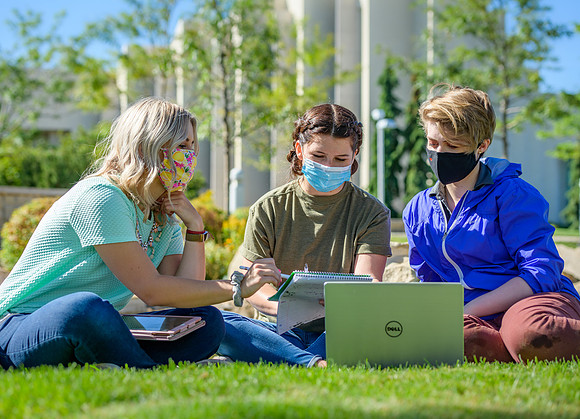 Student volunteers show the way to stay safe during this COVID 19 pandemic by social distancing, following pathway arrows and proper wearing of masks .