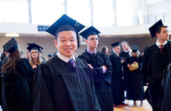 Graduates wait inside the gym area preparing to enter Commencement ceremony.