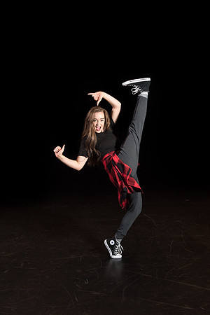 A dance student strikes a pose on the stage.