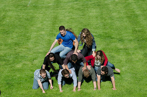 Students build and topple in a human pyramid.