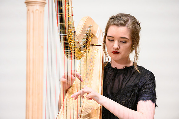 The harp ensemble performs in the recital hall in the Snow building.