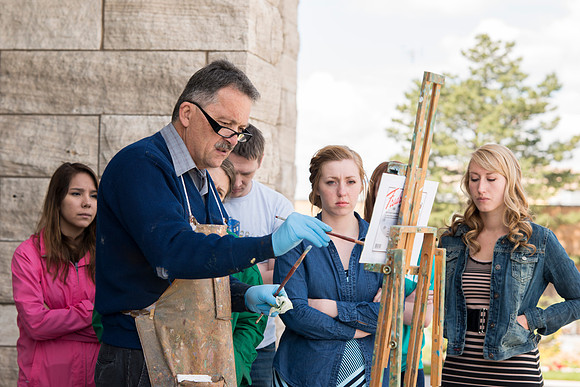 Brother Bodily gives a painting demonstration during his Oil Painting class outside the Spori Building.