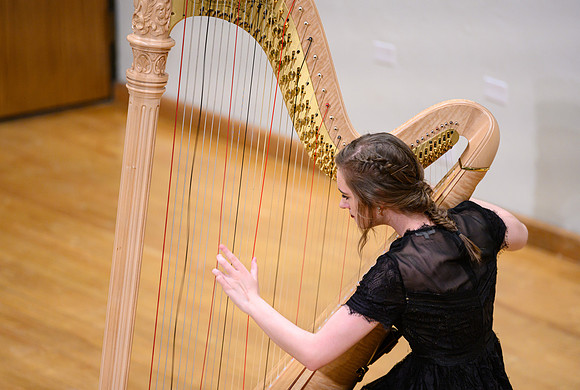 The harp ensemble performs in the recital hall in the Snow building.