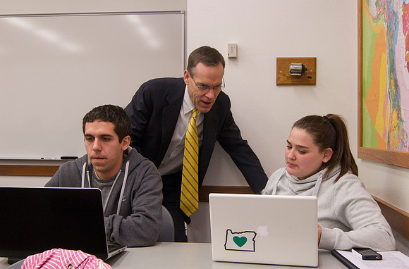 Brother Clark takes time to help a student in his Business Productions and Operations Management class.