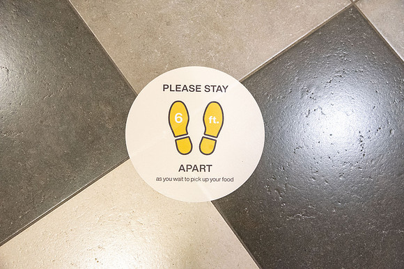 Stickers on the ground in the Crossroads saying to stand 6ft apart and practice physical distancing during the 2020 COVID-19 pandemic.