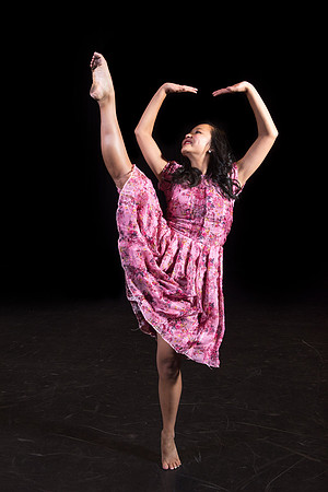 A dance student strikes a pose on the stage.