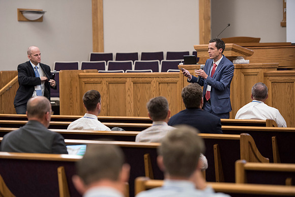 Tim Rarick and Cole Ratcliffe hold a discussion during the faculty conference.