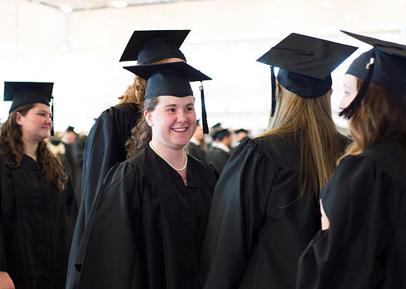 Graduates wait inside the gym area preparing to enter Commencement ceremony.