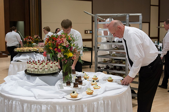 Faculty and students from the Catering Services on campus arrange the dessert table for PAC in the MC during the 2014 Spring Semester.