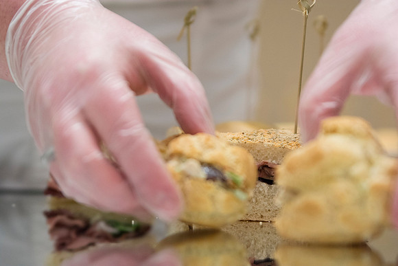 A student prepares places sandwich on a mirrored serving suface for PAC during the 2014 Spring Semester in the MC.