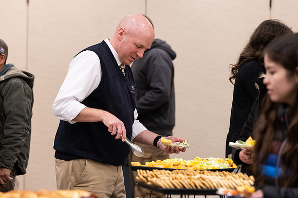 Employees gather for the annual Christmas gathering with President and Sister Meredith.
