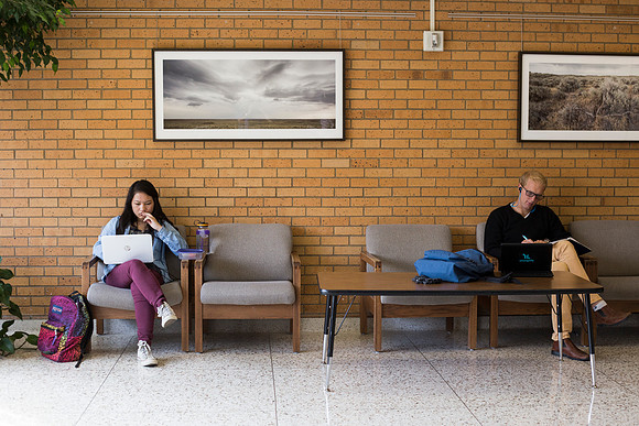 Students prepare for their classes, in the McKay Library.