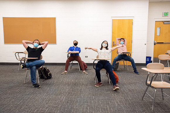 Examples of students staying safe and healthy during the COVID-19 pandemic by social distancing, following pathway arrows, and wearing face masks.