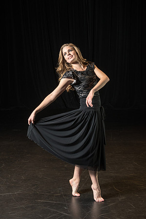 A dance student strikes a pose on the stage.