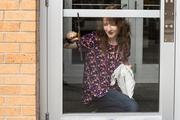 Student employees clean the library windows.