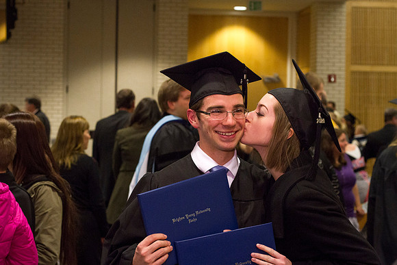 A graduate receives a kiss in the Taylor Chapel after Convocation.
