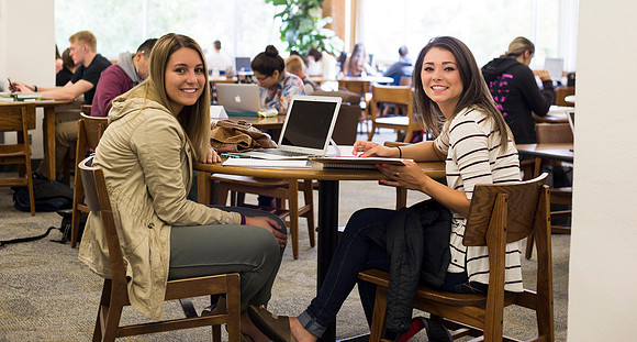 Students prepare for their classes, in the McKay Library.