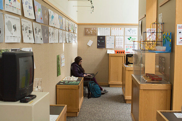 Student studying in the 3rd floor of the Spori, surrounded by an art gallery put on by the students.