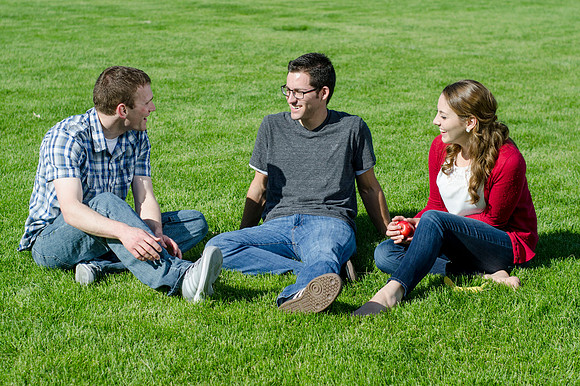 Three friends laugh and enjoy talking on a sunny morning.