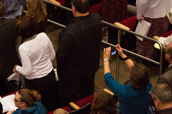 A proud mother of a graduate takes a picture during Commencement in the I-Center.
