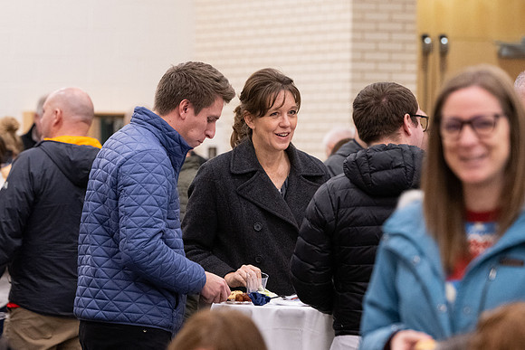 Employees gather for the annual Christmas gathering with President and Sister Meredith.