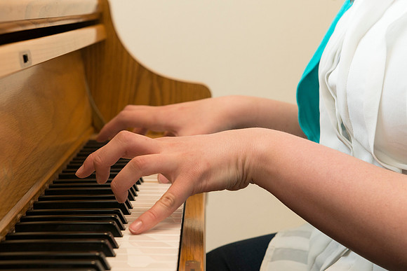 Students practice playing the piano for the new housing promo pictures.