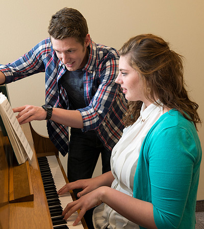 Students practice playing the piano for the new housing promo pictures.