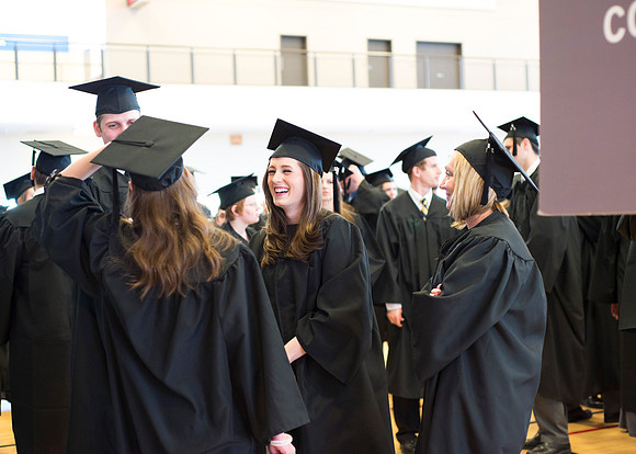 Graduates wait inside the gym area preparing to enter Commencement ceremony.
