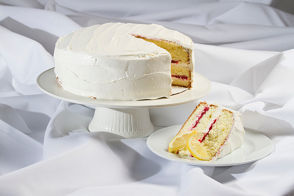 A moist vanilla cake topped with creamy frosting and filled with raspberries.