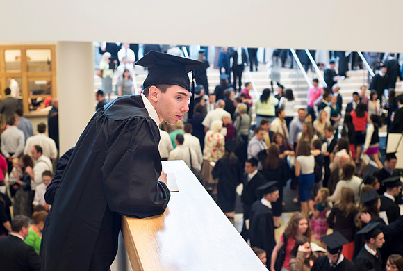 A graduate searches for familar faces in the crowd.