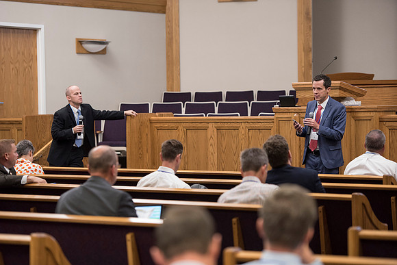 Tim Rarick and Cole Ratcliffe hold a discussion during the faculty conference.