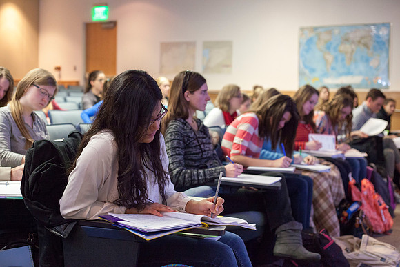 Students eagerly take notes as Brother Madsen covers various Geography topics.