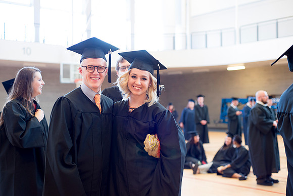 Graduates wait inside the gym area preparing to enter Commencement ceremony.