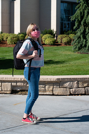 Examples of students staying safe and healthy during the COVID-19 pandemic by social distancing, following pathway arrows, and wearing face masks.