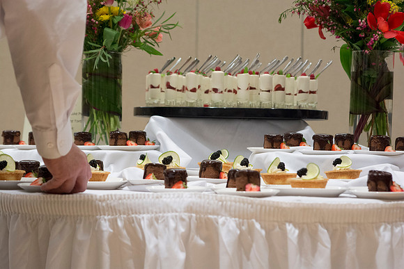 Faculty and students from the Catering Services on campus arrange the dessert table for PAC in the MC during the 2014 Spring Semester.