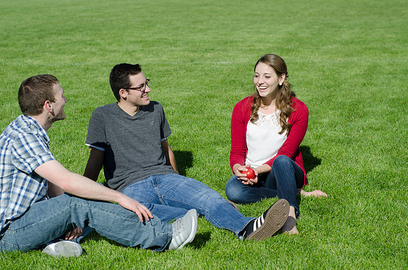 Three friends laugh and enjoy talking on a sunny morning.