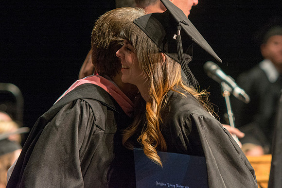 Faculty members hand degrees to and congratualate graduates of the College of Performing and Visual Arts.