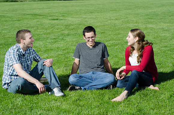 Three friends laugh and enjoy talking on a sunny morning.
