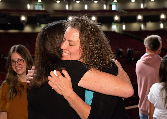 Sister Heather Hall huging her family after devotional.