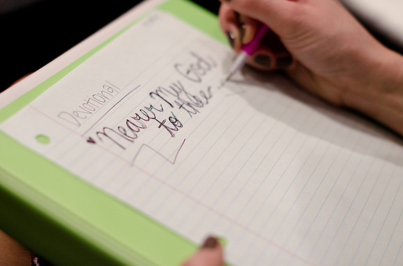 Student preparing to write notes at devotional.