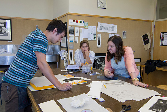 Students in Sister Jimison's Printmaking compare the original sketch to the finished product after having gone through the press.