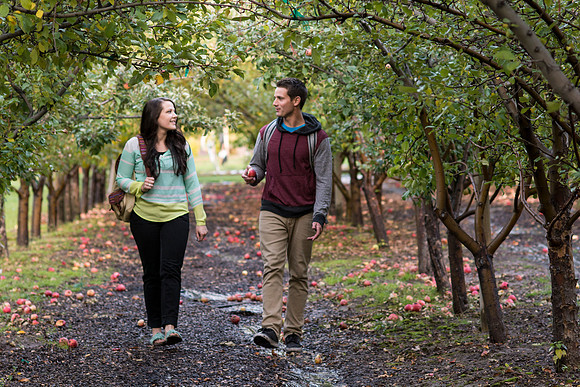 Jacob Justice and Hannah Moore walk through the Apple Orchard on campus.