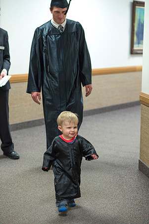 A son of a graduate wears his own gown to match his father.