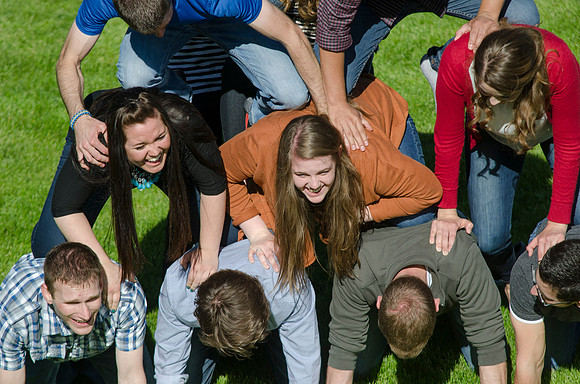 Students build and topple in a human pyramid.