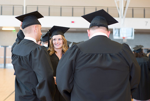 Graduates wait inside the gym area preparing to enter Commencement ceremony.