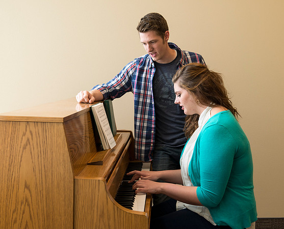 Students practice playing the piano for the new housing promo pictures.