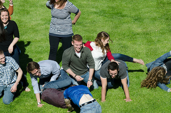 Students build and topple in a human pyramid.
