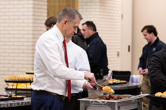 Employees gather for the annual Christmas gathering with President and Sister Meredith.